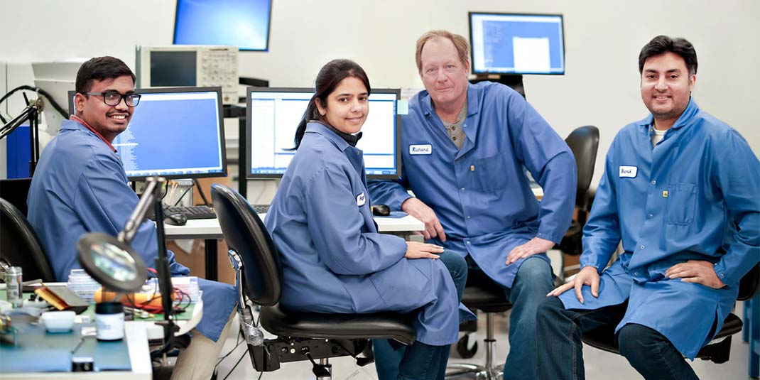 SiTime employees wearing lab coats working in lab