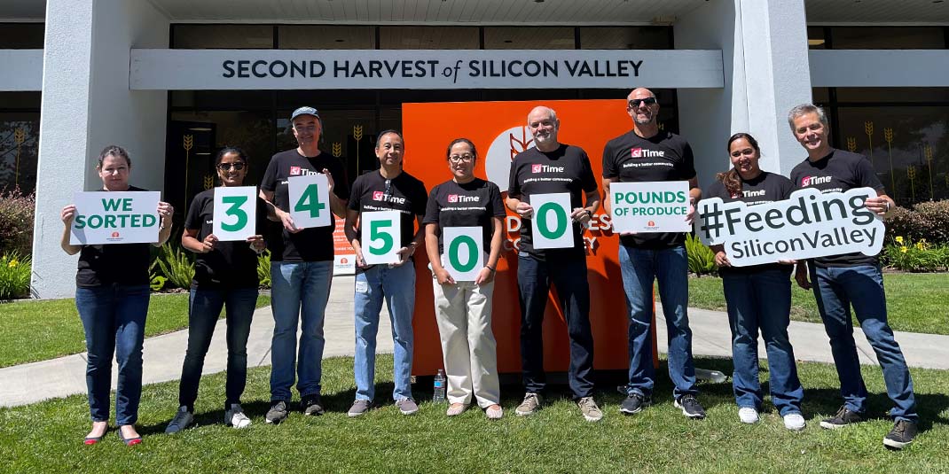 SiTime employees holding signs that together read as "We sorted 34500 pounds of produce", "#Feeding Silicon Valley"
