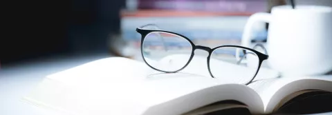 glasses resting on top of open book