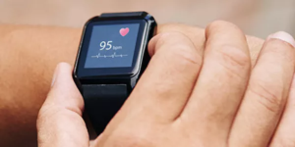 Close-up image of sportsman checking his pulse on smart watch