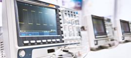 Close up of hand turning dial of modern electronic oscilloscope. Electronic engineer using EMI receiver during experiments or testing equipment in laboratory