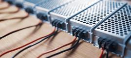 Close up of the metal mesh cases of power supply and wires are on a wooden table