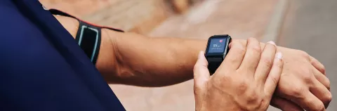 Close-up image of sportsman checking his pulse on smart watch