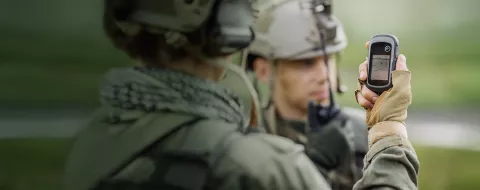 Soldier's holding gps in hand and determines the location of coordinates while the second soldier is using the radio for communication during military operation
