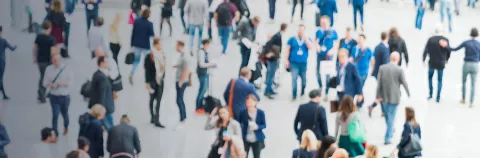 Large crowd of anonymous blurred people at a tradeshow