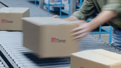 close up of a person loading a shipping box on a conveyor belt showing motion