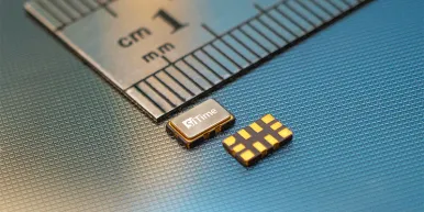 SiTime Elite RF parts, 5.0x3.5 mm in size, shown by a ruler on a silicon wafer background