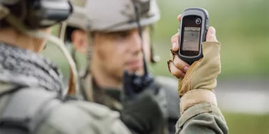 Soldier's holding gps in hand and determines the location of coordinates while the second soldier is using the radio for communication during military operation